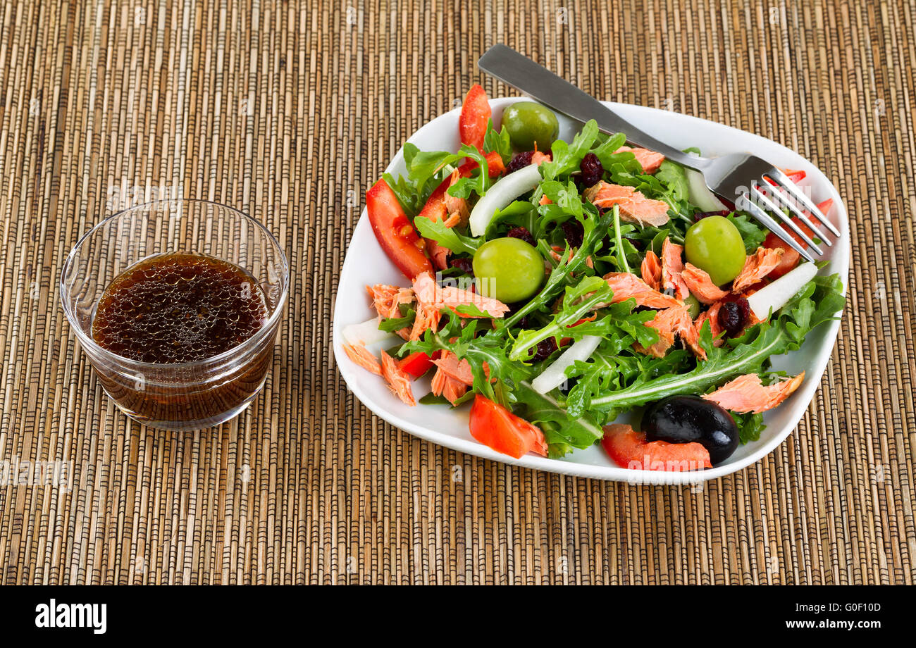 Frische gesunde Salat und Dressing auf natürlichem Bambus Tischset Stockfoto