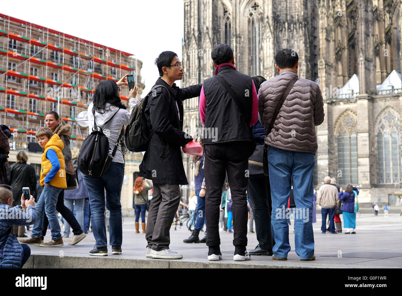 Touristen aus Asien am Fuße des Kölner Cathedra Stockfoto