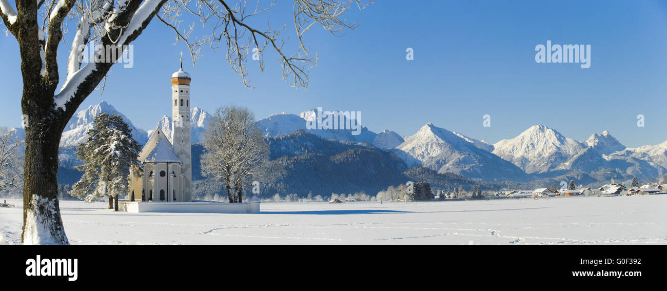 große Panorama-Landschaft in Bayern mit Kirche St. Coloman im Winter im Schnee Stockfoto