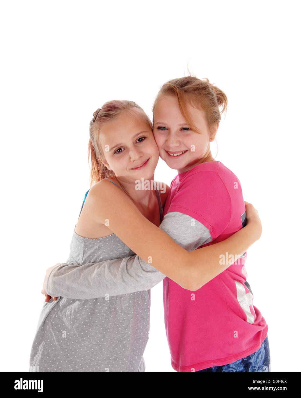Lächelnde Schwestern umarmen einander. Stockfoto