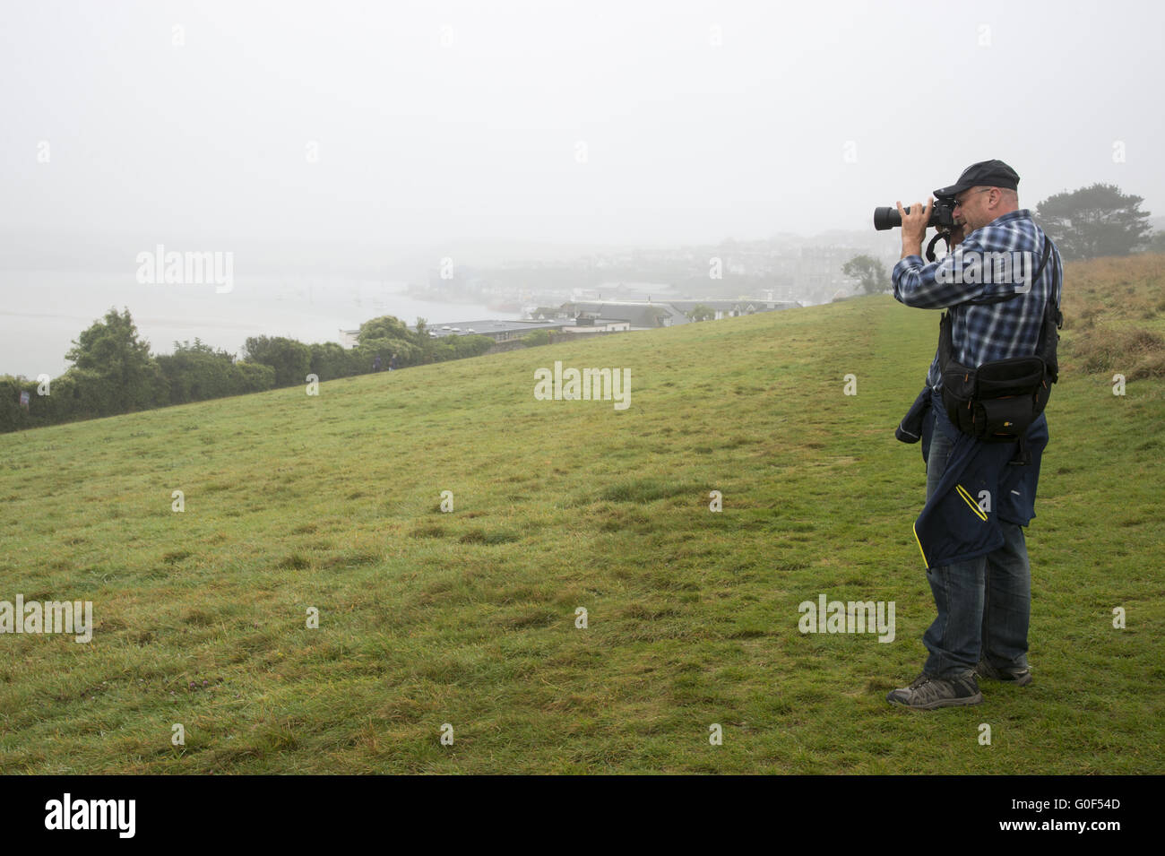 Ein Fotograf in den Hügeln oberhalb des Hafens von Padstow Stockfoto