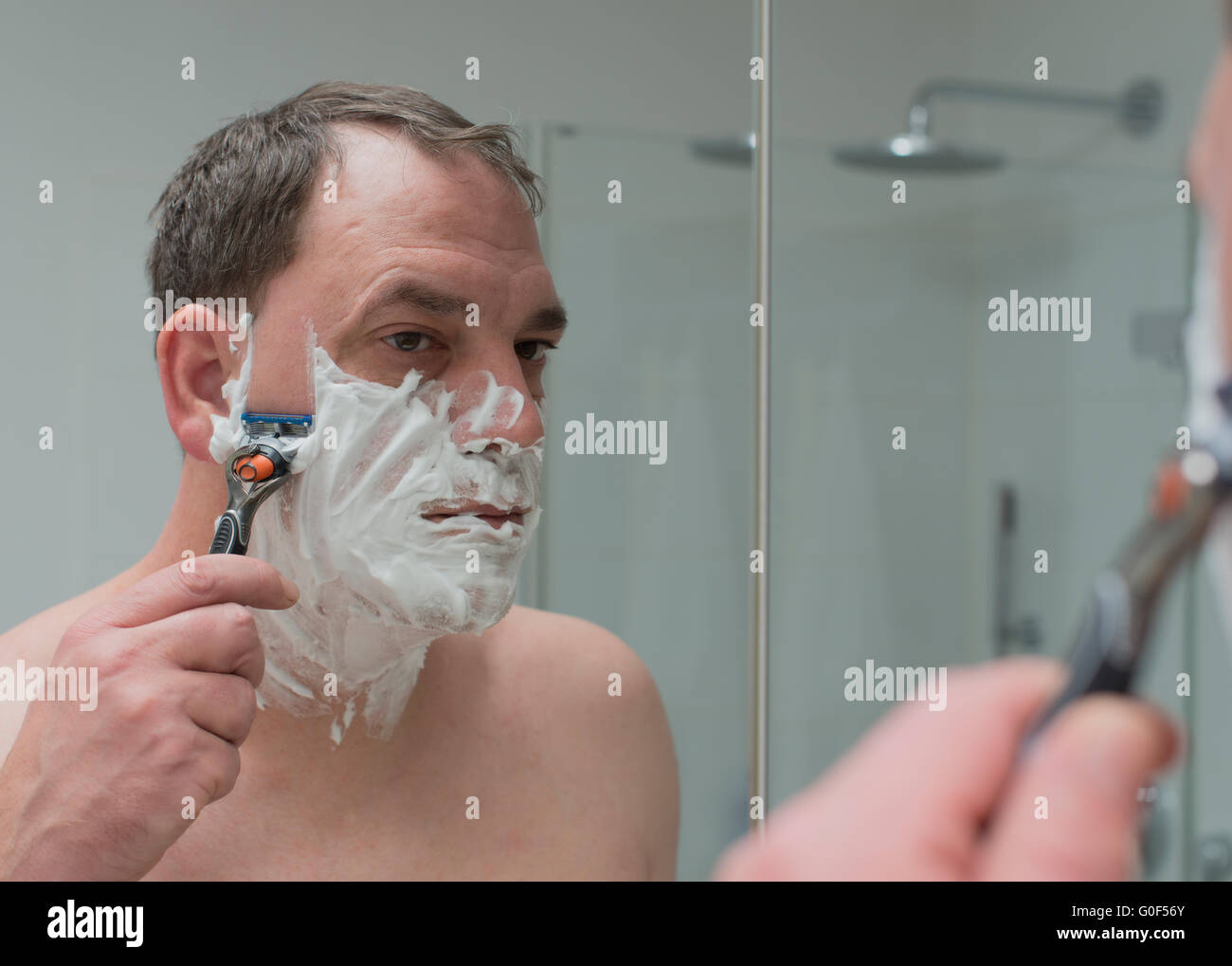 Mann rasiert sich das Gesicht Stockfoto
