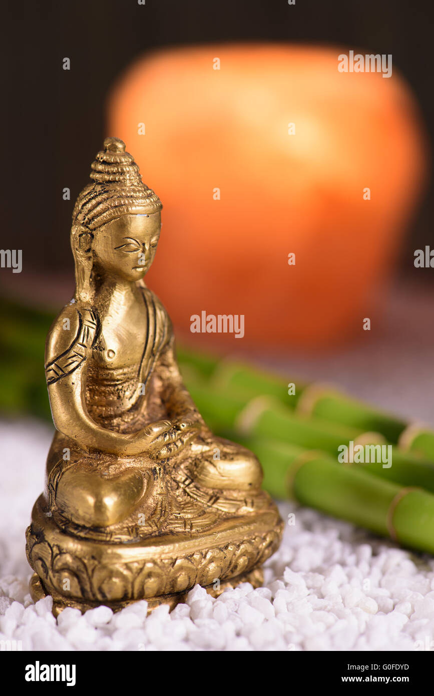 Buddha-Gestalt, die sitzen in der Meditation vor Salzlampe Stockfoto