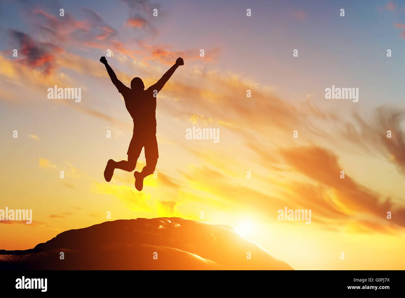 Glücklicher Mann springen vor Freude auf dem Gipfel des Berges Stockfoto