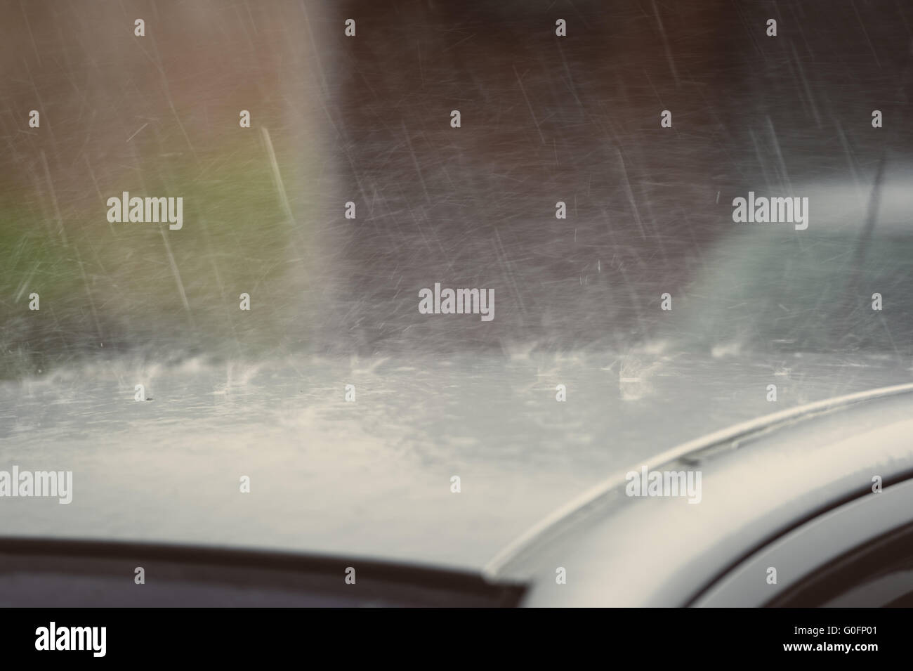 Regen fällt auf dem Dach eines Autos Stockfoto