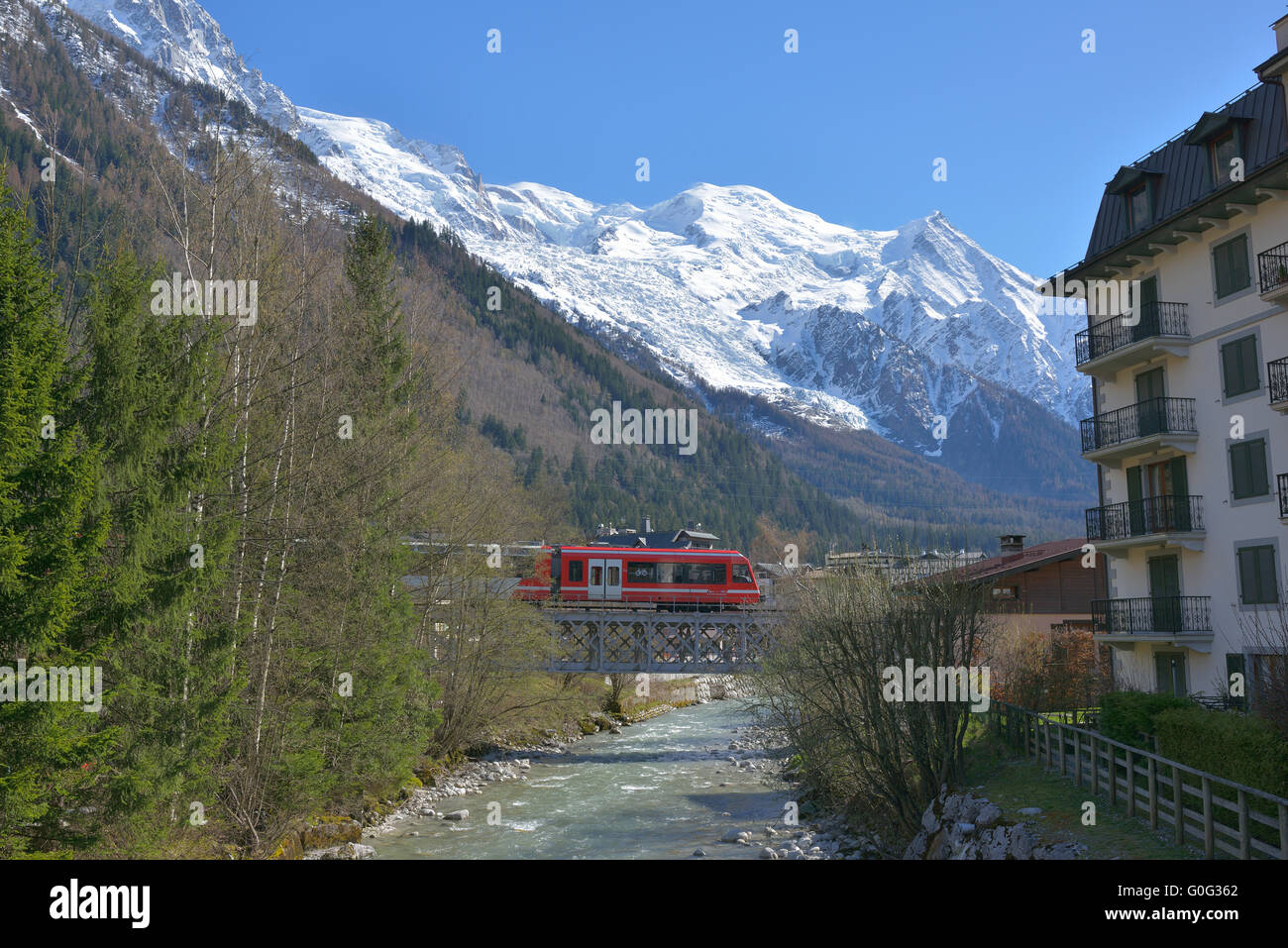Touristenzug auf einer Schotterbrücke über den Fluss Arve und mit Mont-Blanc als Hintergrund. Chamonix, Haute-Savoie, Auvergne-Rhône-Alpes, Frankreich. Stockfoto