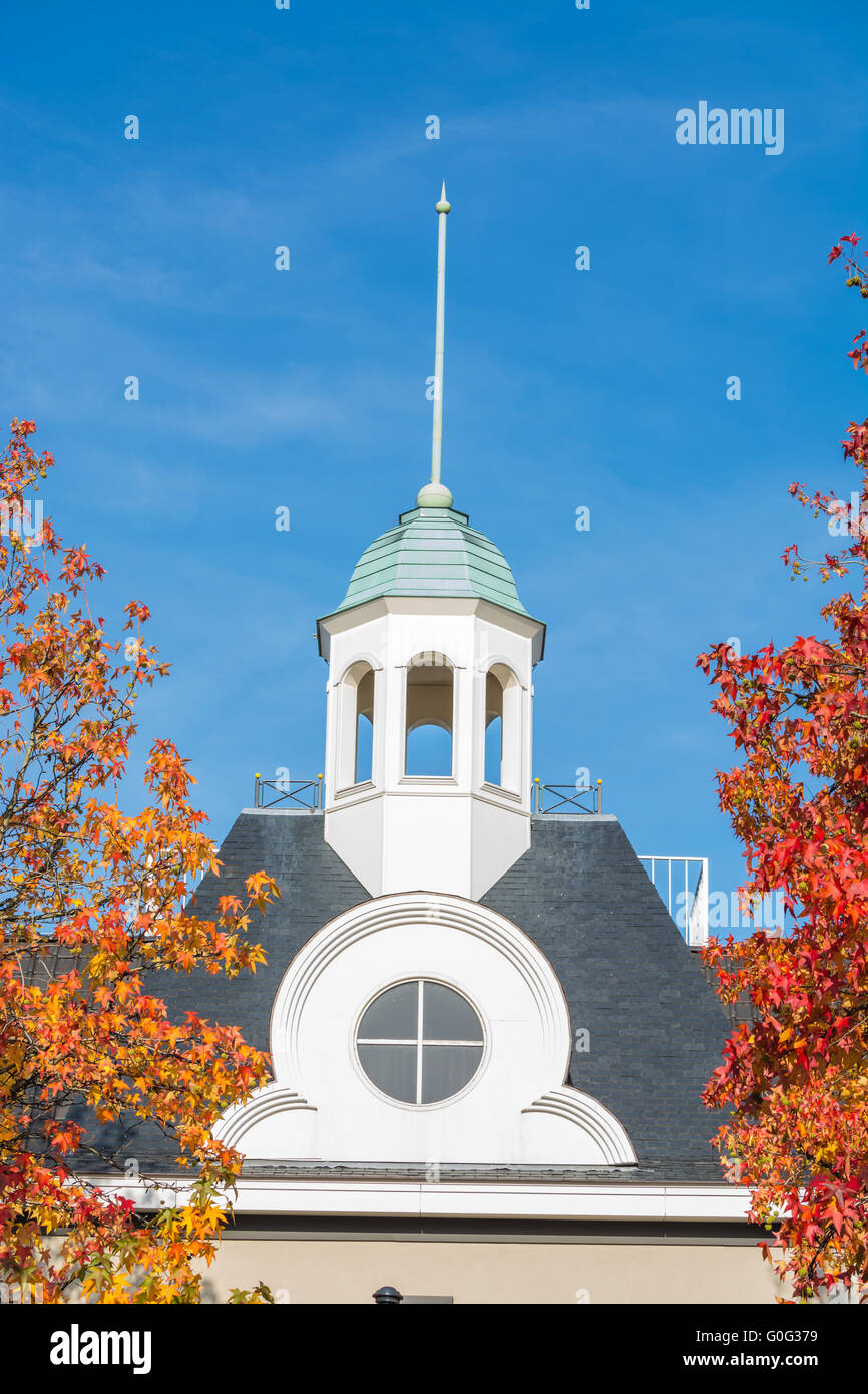 Kirchturm und Bäume mit Herbstlaub Stockfoto