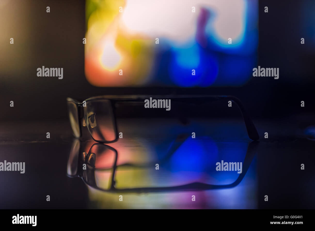 Ein paar Gläser auf dem Tisch vor dem laufenden Fernseher Stockfoto