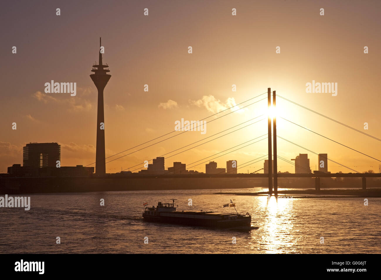 Der Rhein mit Frachtschiff, Stadttor, dem Rheinturm und Rheinkniebruecke, Düsseldorf, Deutschland Stockfoto