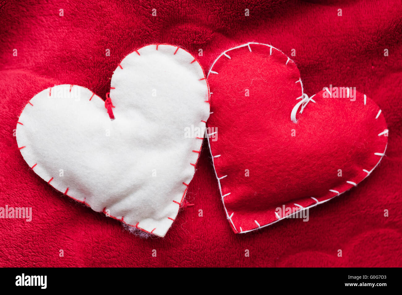 Handgemachte plüschige rote Herzen paar auf weiche Decke. Romantische Liebe Stockfoto