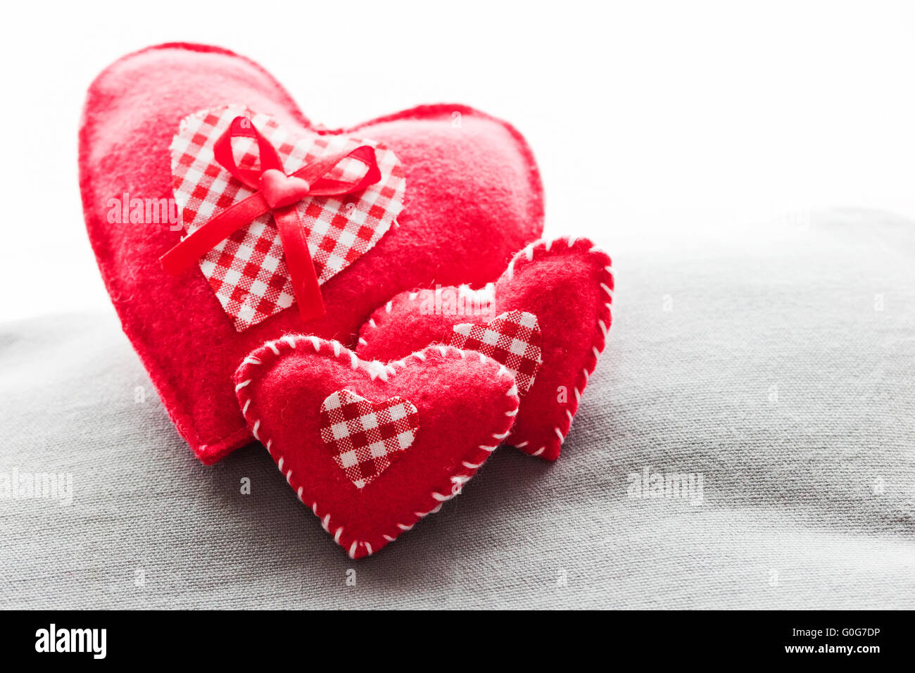 Handgemachte Plüsch rote Herzen auf dem weichen Kissen. Romantische Liebe Stockfoto