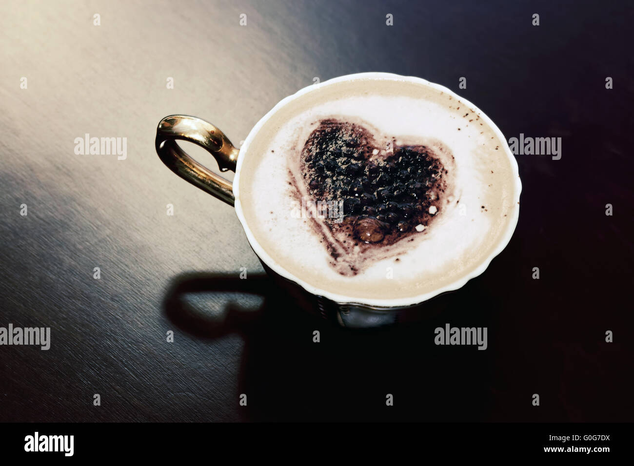 Tasse Kaffee mit Schokolade Herzform auf Milchschaum. Romantische Morgenlicht. Stockfoto