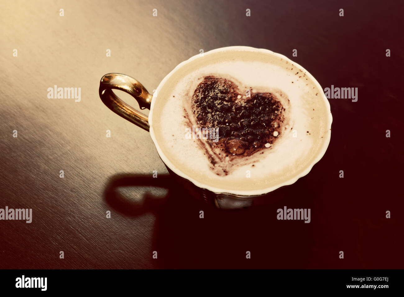 Tasse Kaffee mit Schokolade Herzform auf Milchschaum. Romantische Morgenlicht. Jahrgang Stockfoto