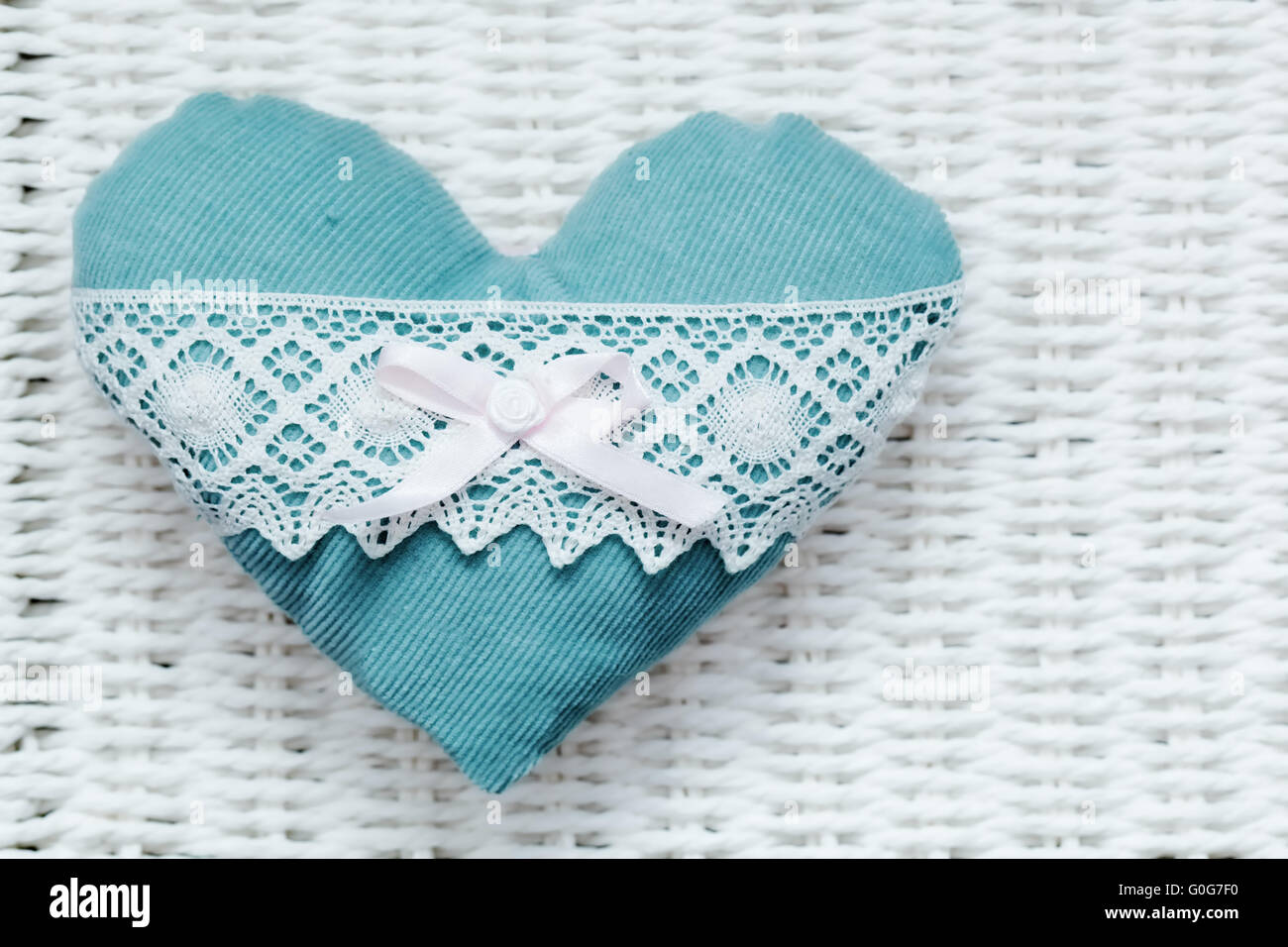 Vintage handgemachte Plüsch Türkis Herz auf weißen rustikale geflochtenen. Romantische Liebe Stockfoto