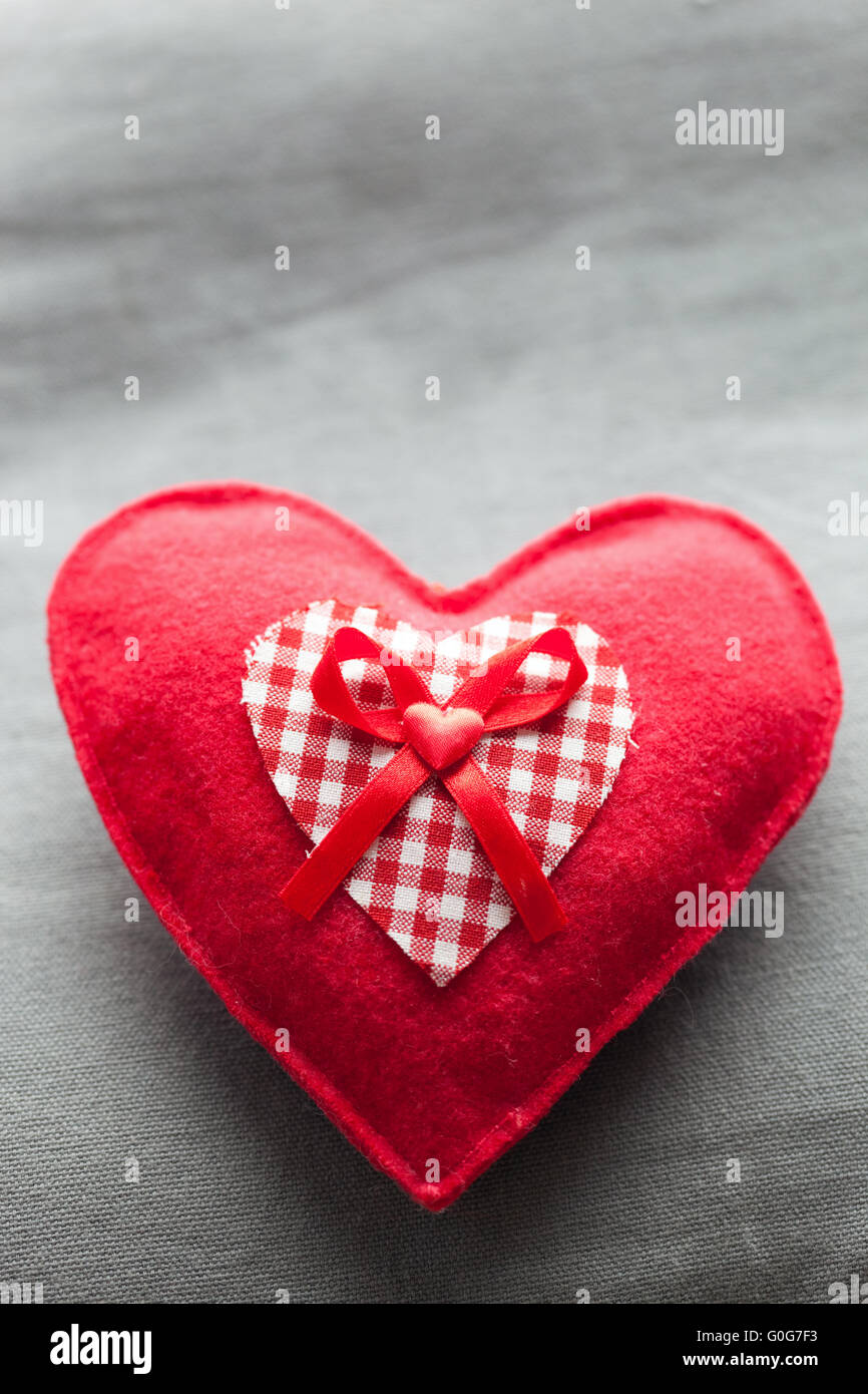Handgemachte Plüsch rotes Herz auf dem weichen Kissen. Romantische Liebe Stockfoto