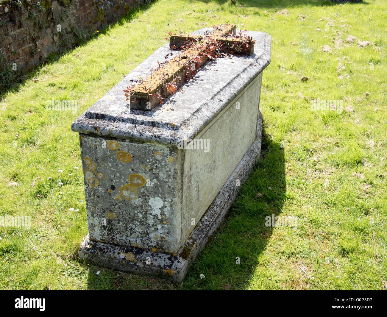 Einem steinernen Sarg-förmigen Grab mit einem Kreuz an der Spitze. Stockfoto