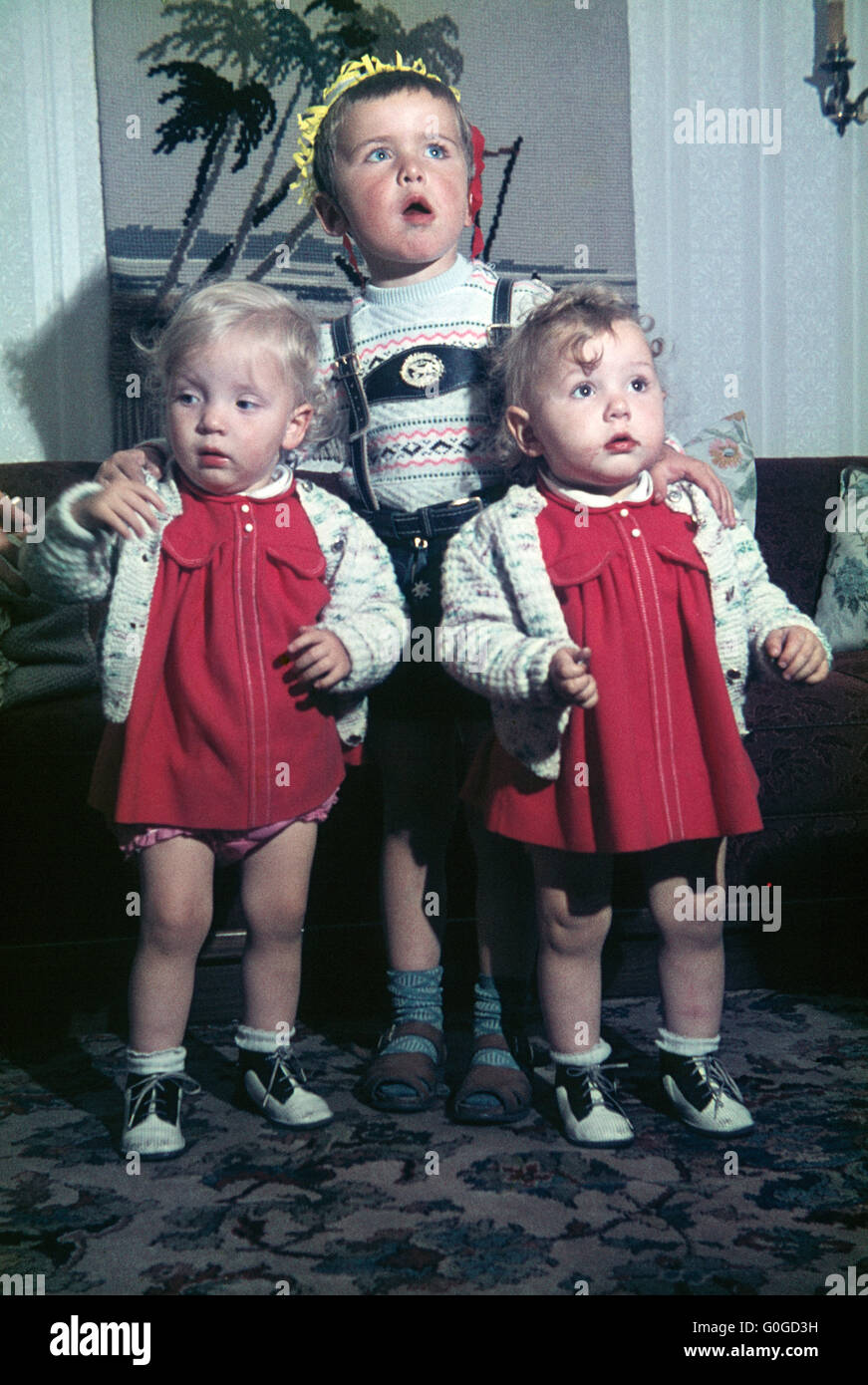 Sechziger Jahre, Kinder, jungen 6 bis 8 Jahren und zwei Zweibettzimmer Mädchen 3 bis 4 Jahren posiert in einem Wohnzimmer, Frank Stockfoto