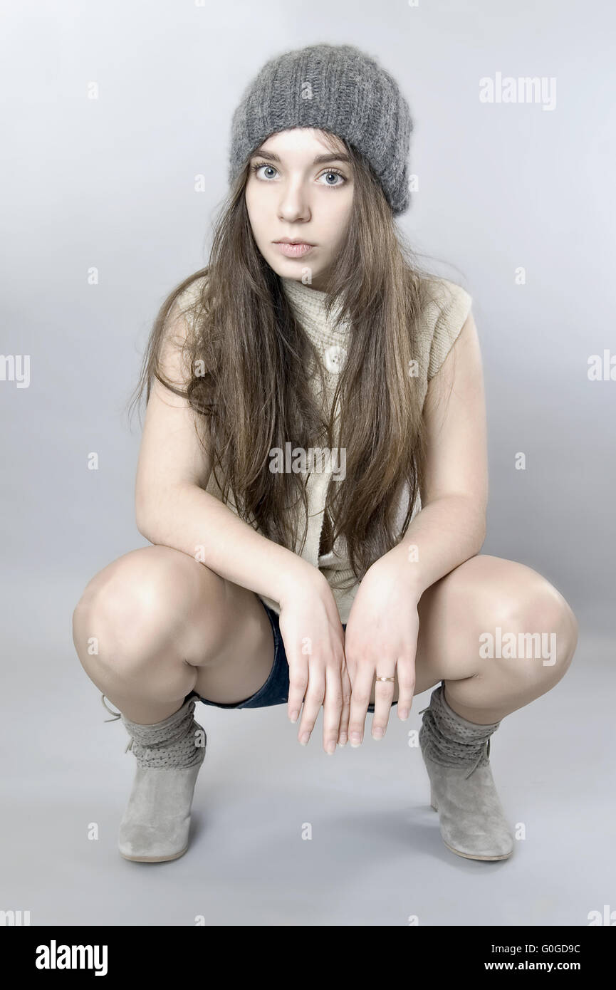 Porträt eines jungen Mädchens, das auf seine Hüften sitzt. Stockfoto