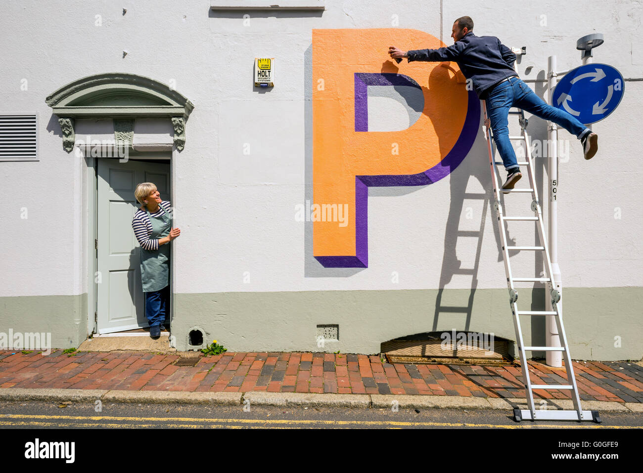 Wir feiern 100 Jahre London unterirdische Welt berühmte Schrift, malt der Künstler Gary Stranger Briefe an Wänden in Ditchling. Stockfoto