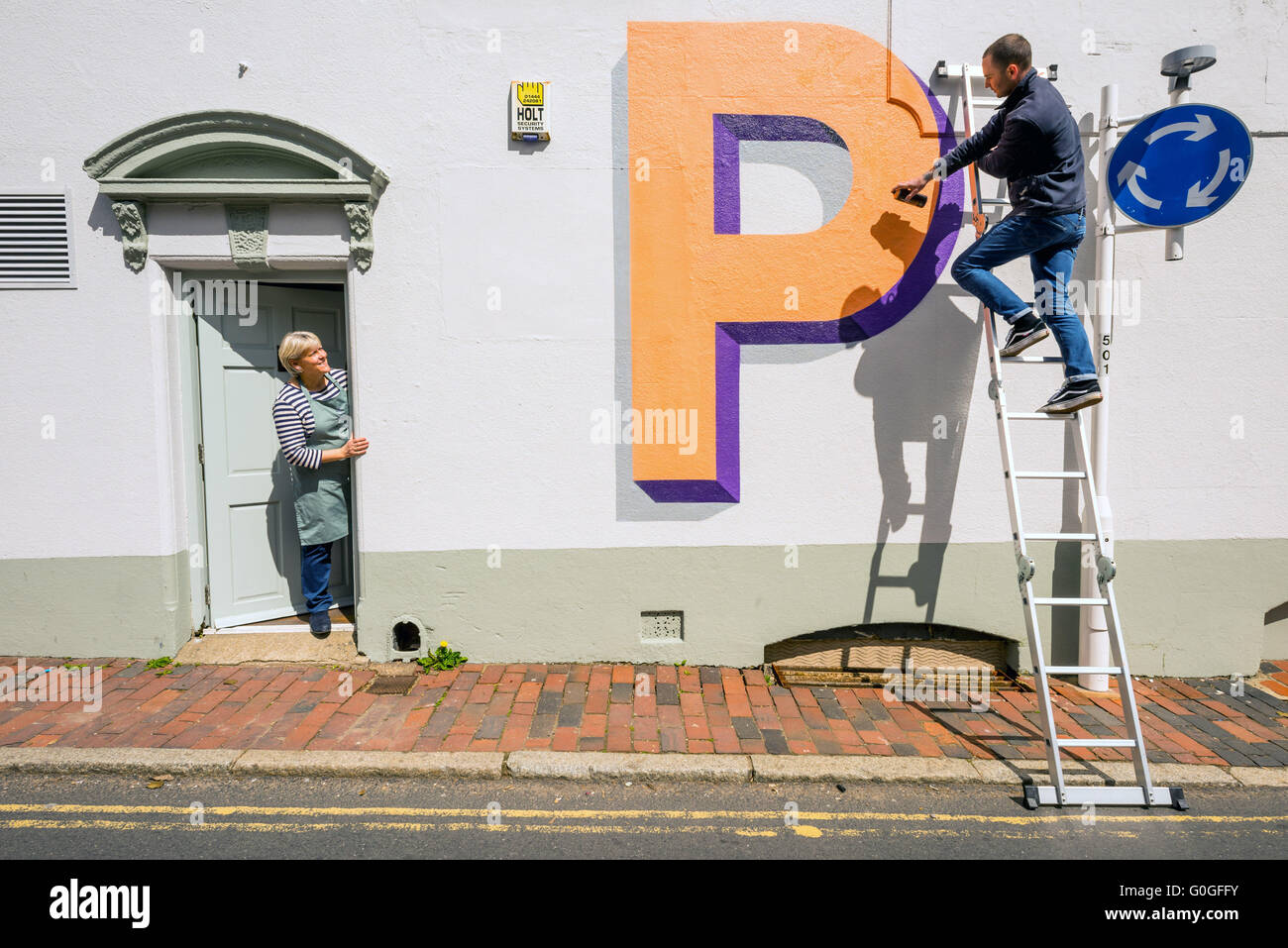 Wir feiern 100 Jahre London unterirdische Welt berühmte Schrift, malt der Künstler Gary Stranger Briefe an Wänden in Ditchling. Stockfoto