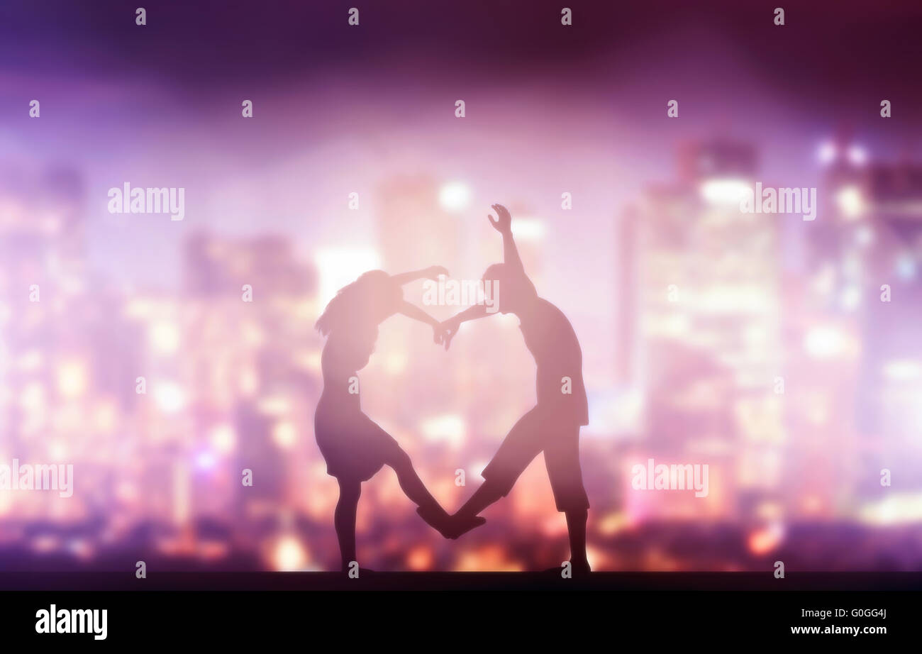 Glückliches Paar in Liebe Herzform machen. Stadt bei Nacht Hintergrund. Stockfoto