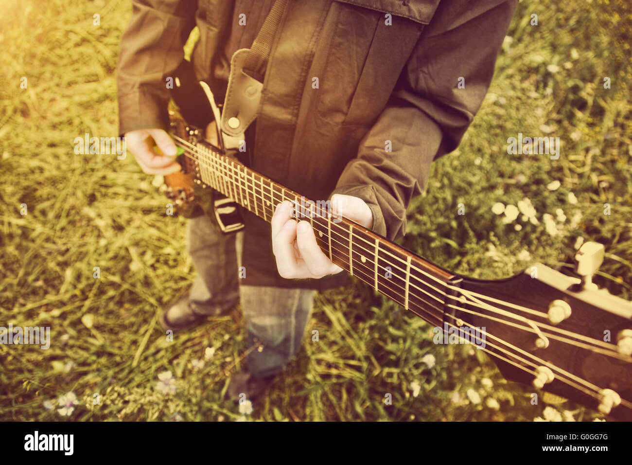 Junger Mann an der Gitarre im Freien spielen. Jahrgang Stockfoto