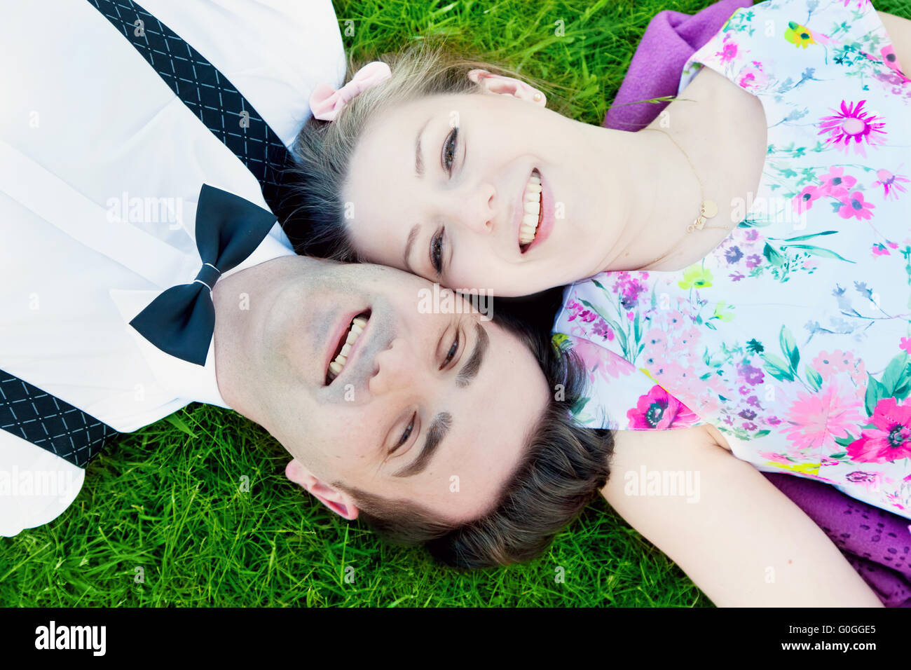 Glückliches Paar in Liebe Sommer Gras liegend und lächelnd Stockfoto
