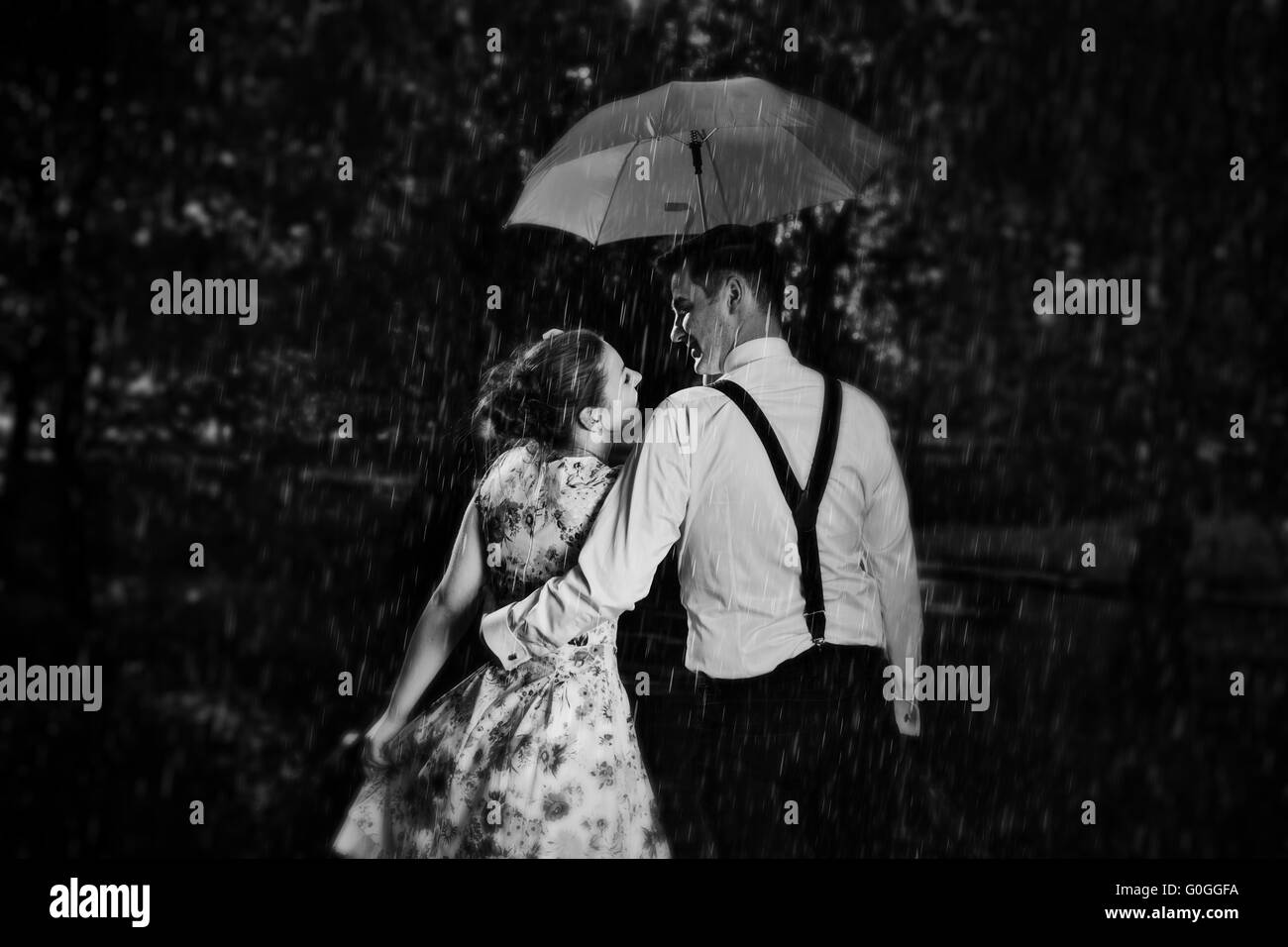 Junge romantische Paar in Liebe Flirten im Regen. Schwarz / weiß Stockfoto