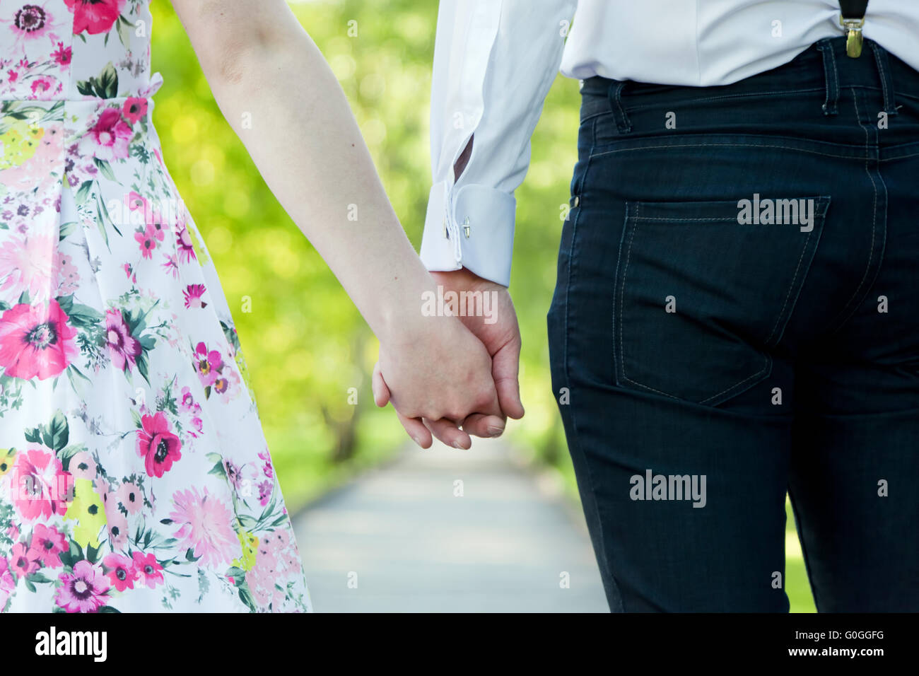 Junges Paar in Liebe Hand in Hand im Sommerpark. Aus dem Stockfoto