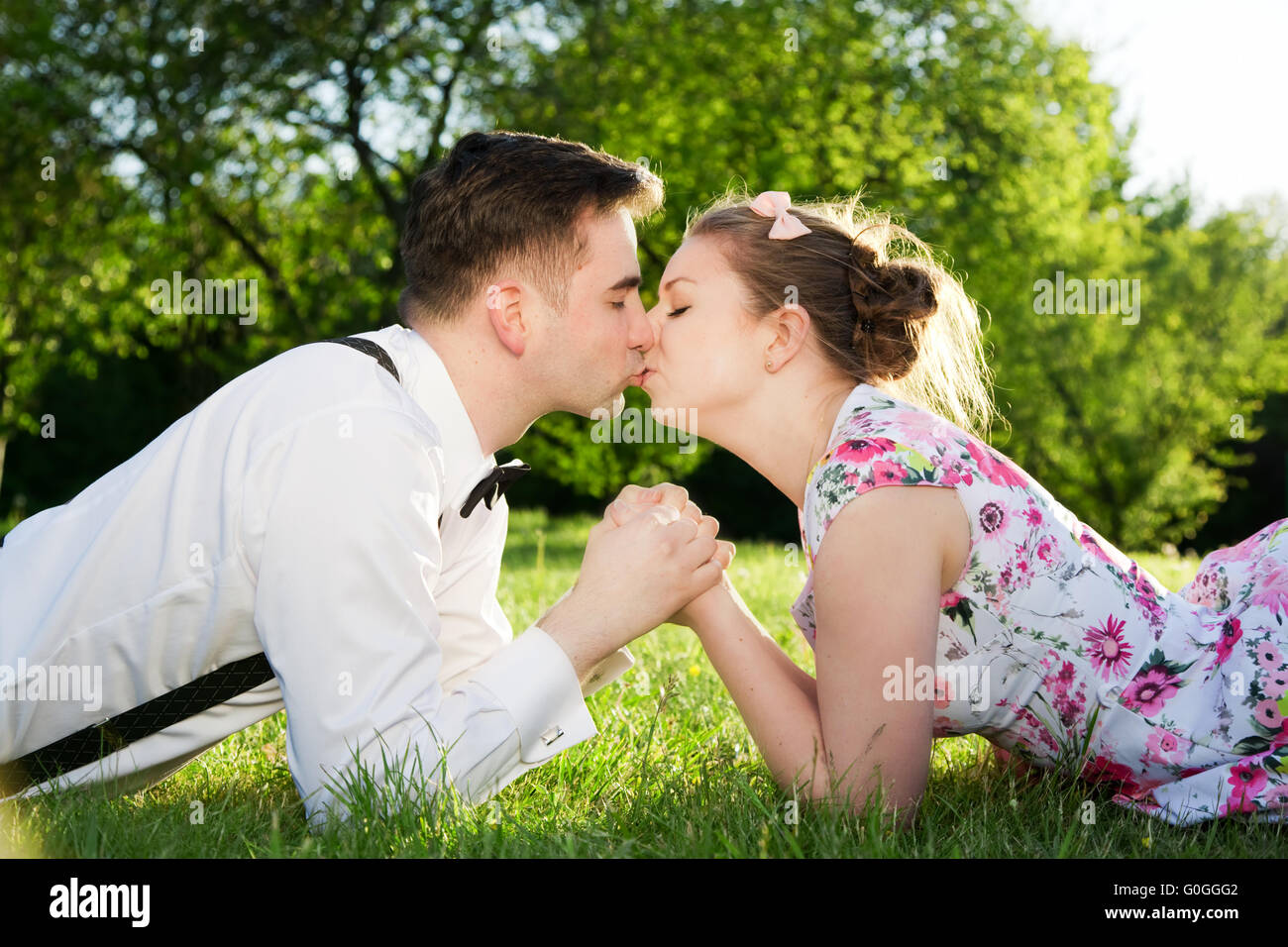 Romantisches Paar verliebt küssen beim liegen auf dem Rasen. Stockfoto