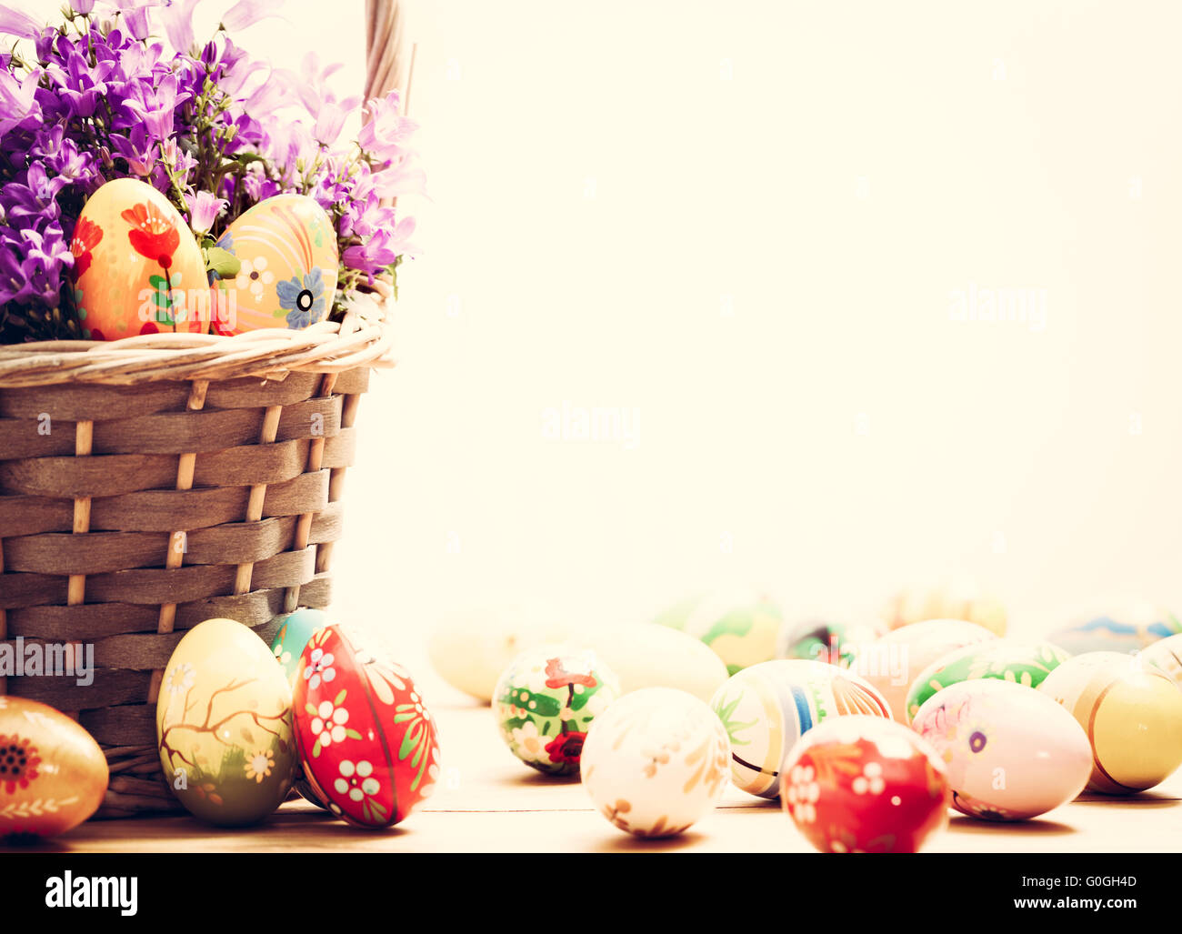 Bunte handbemalte Ostereier im Korb und Holz. Handgemachte Vintage Dekoration Stockfoto