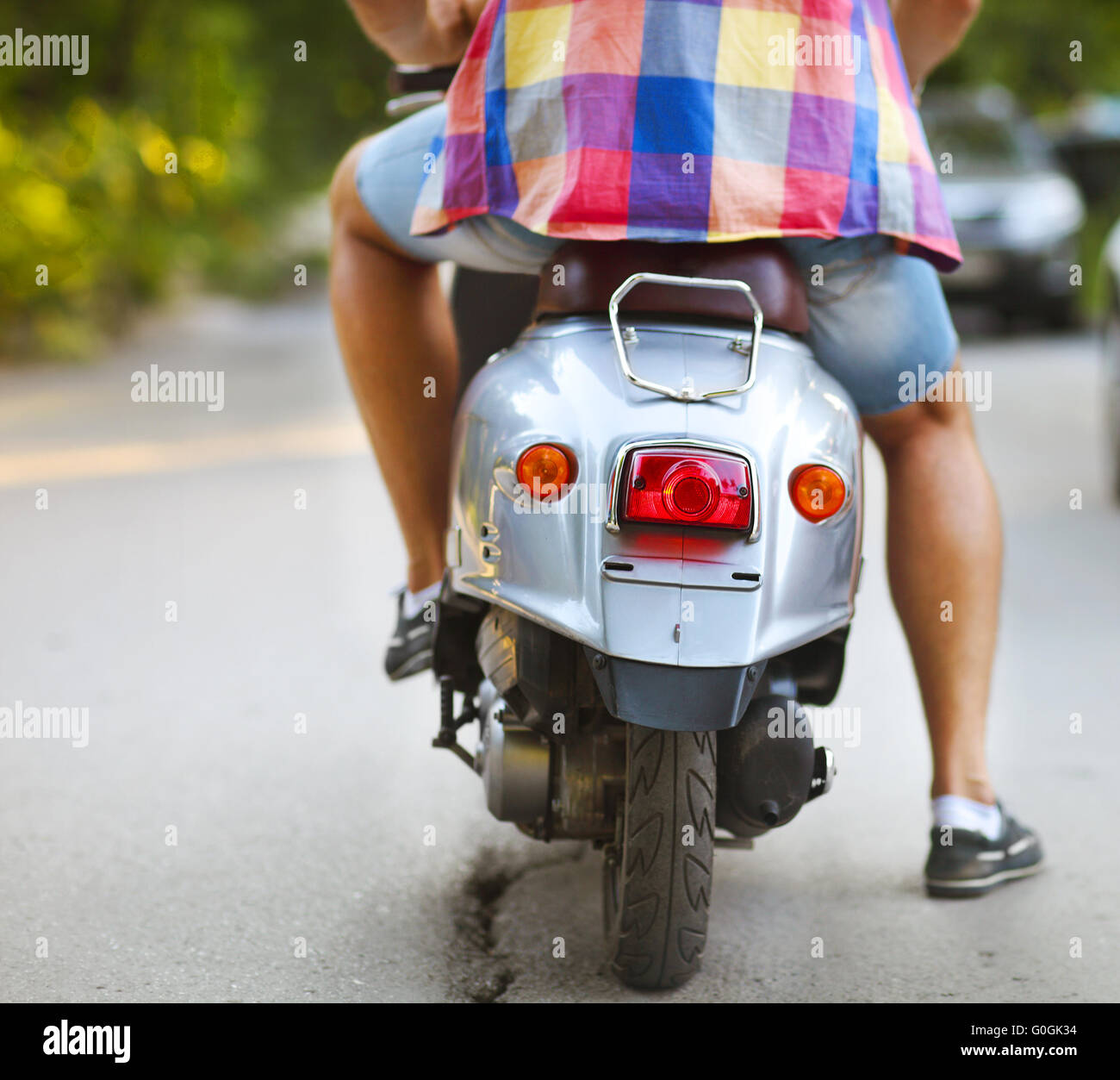 Rückansicht des Jünglings Motorroller entlang der Straße Stockfoto