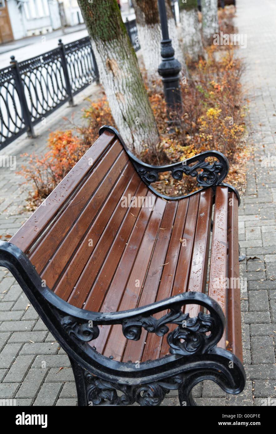 Braune Sitzbank in einem Stadtpark im Herbst Stockfoto