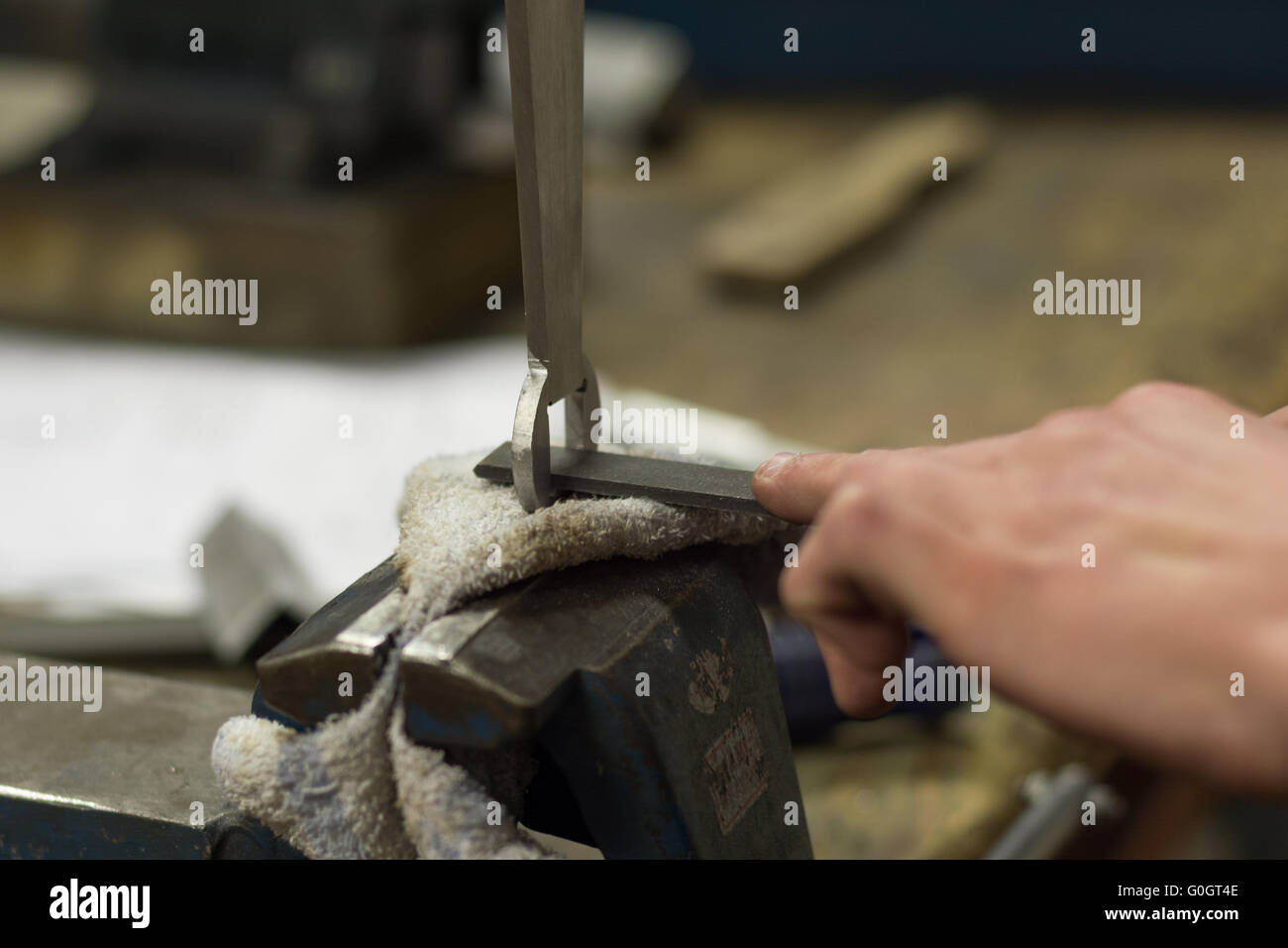 Artisan poliert mit einer flachen Metall-Datei ein Stück Metall - Nahaufnahme Stockfoto