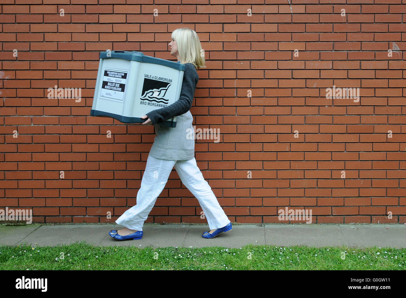 Ein Rat Arbeiter trägt Wahlurnen voller Stimmen bei der Parlamentswahl Auszählung in Barry, South Wales. Stockfoto