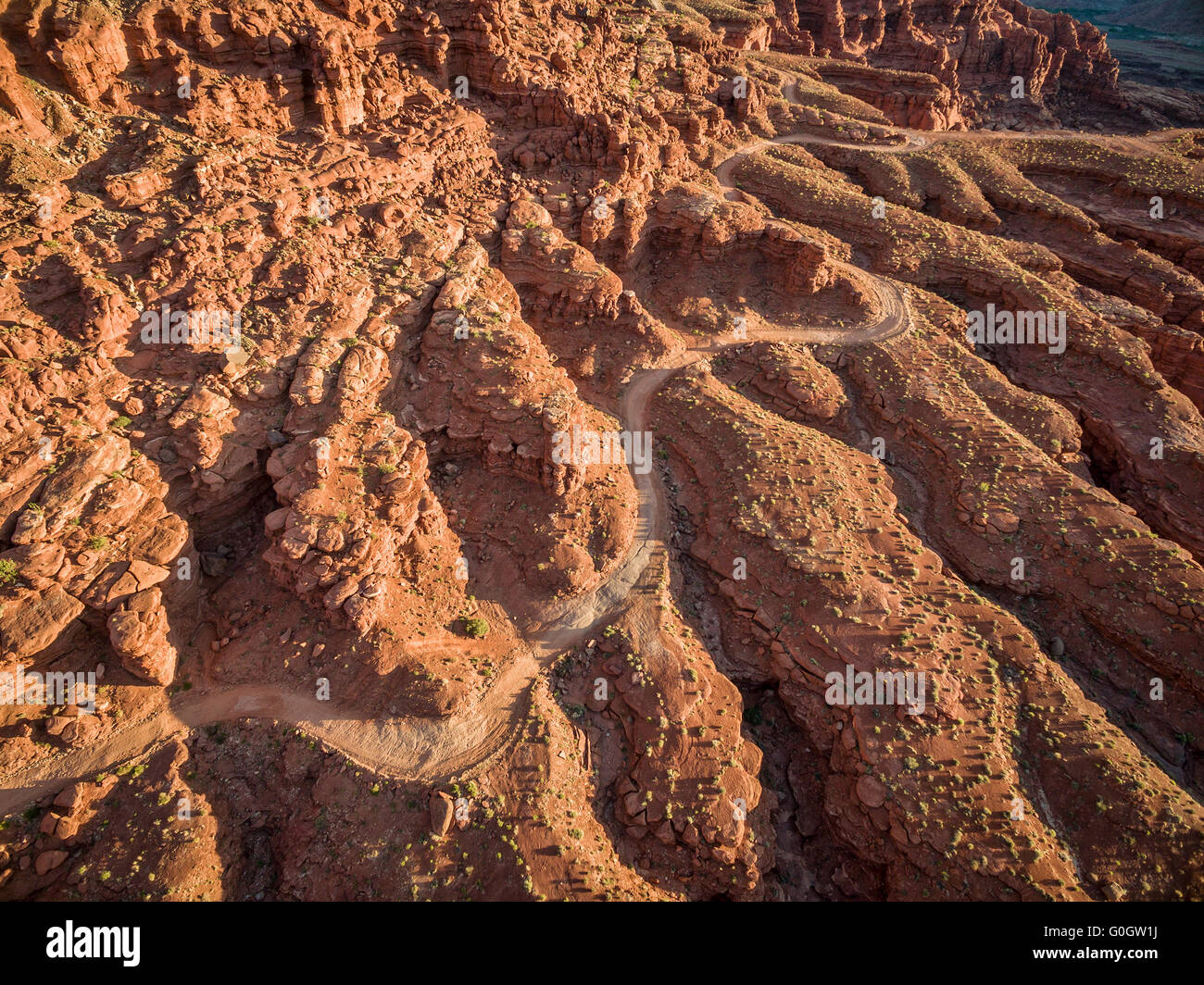 Luftaufnahme einer windigen 4WD Straße durch den Canyon aus rotem Sandstein mit groben Vegetation in der Nähe von Moab, Utah Stockfoto