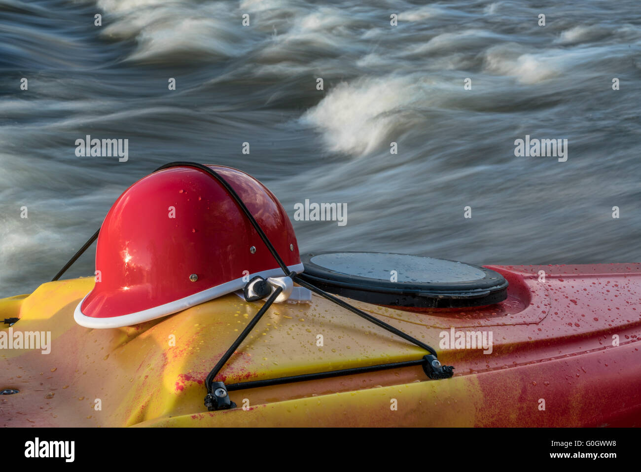 Wildwasser Kajak Helm auf einem Kajak Deck gegen rapid river Stockfoto