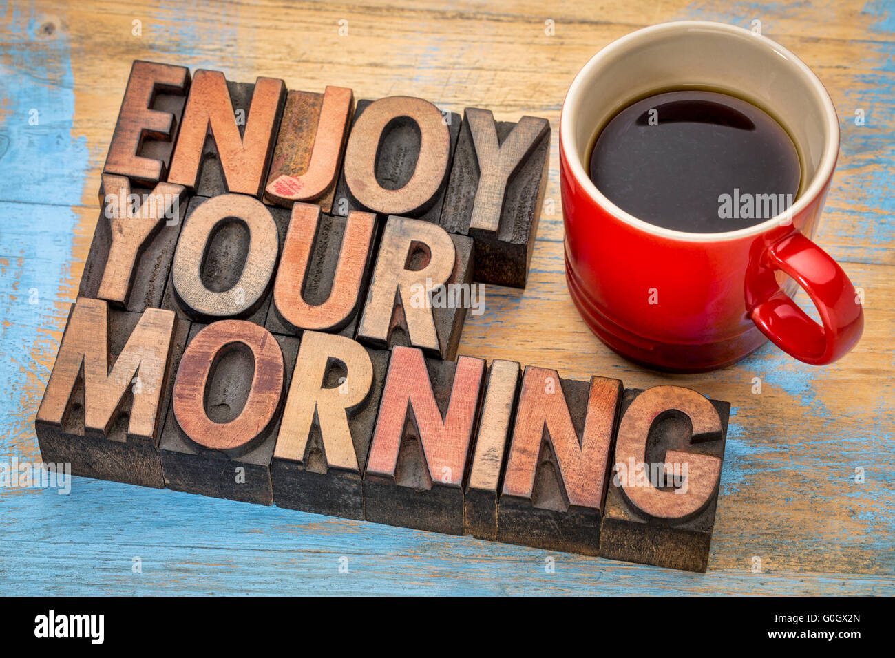 Genießen Sie Ihren Morgen - Zusammenfassung der Wörter in Vintage Buchdruck Holzart Druckstöcke mit Tasse Kaffee Stockfoto
