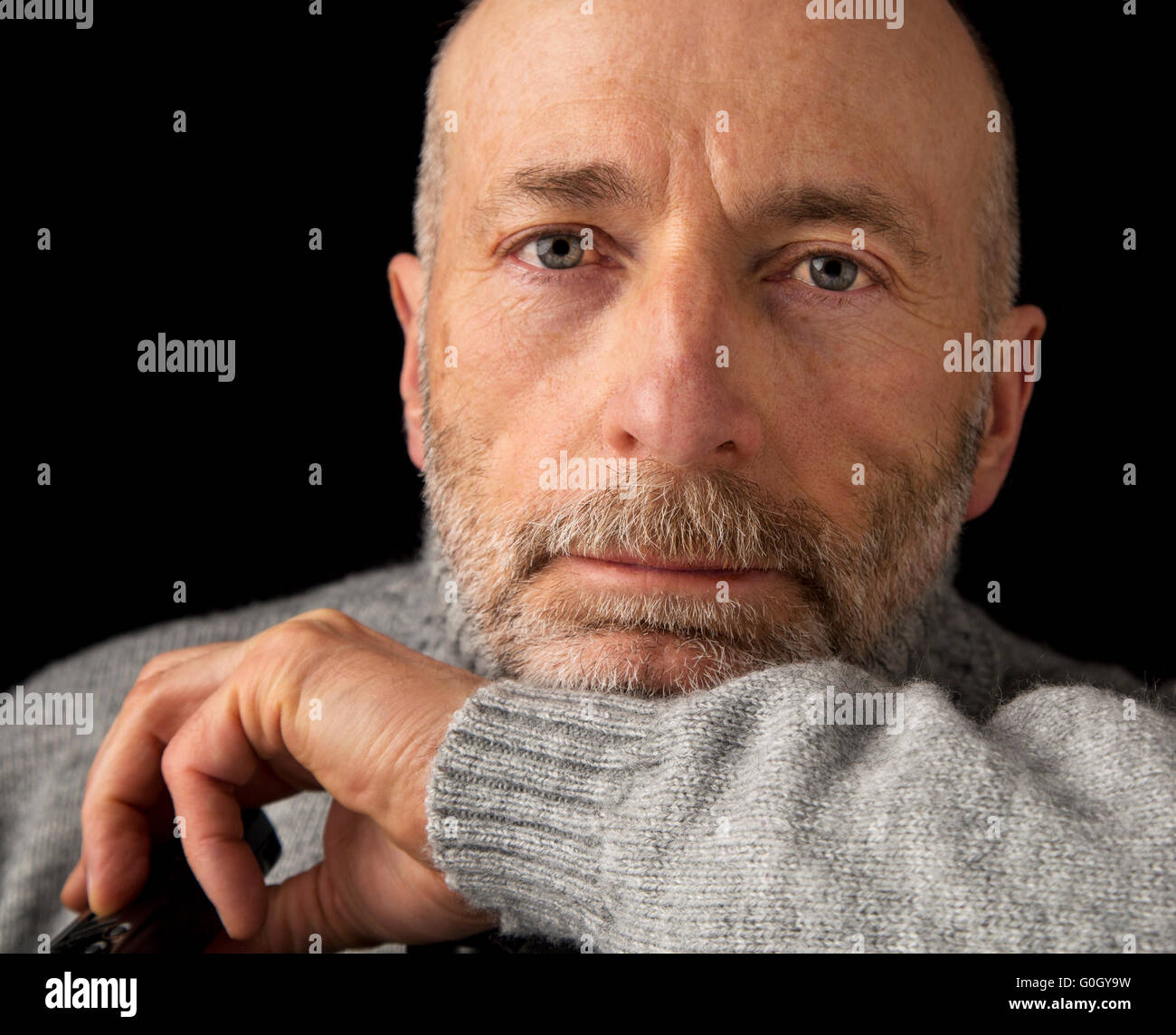 zuversichtlich und positiv 60 Jahre alten Mann mit Bart - ein Kopfschuss vor schwarzem Hintergrund Stockfoto