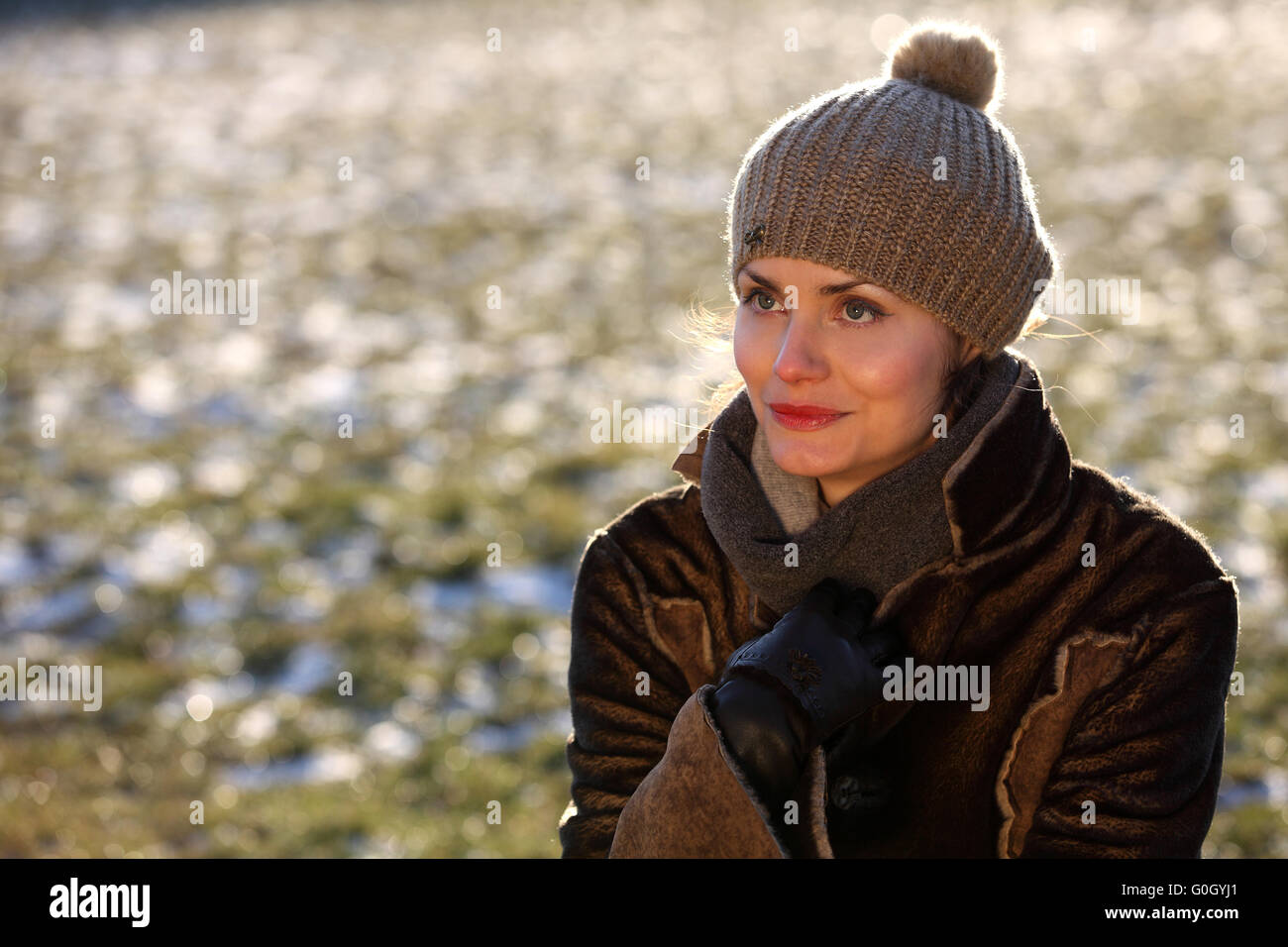 Schöne Mädchen mit Bommel Mütze und Wildleder Jacke im Schnee Stockfoto