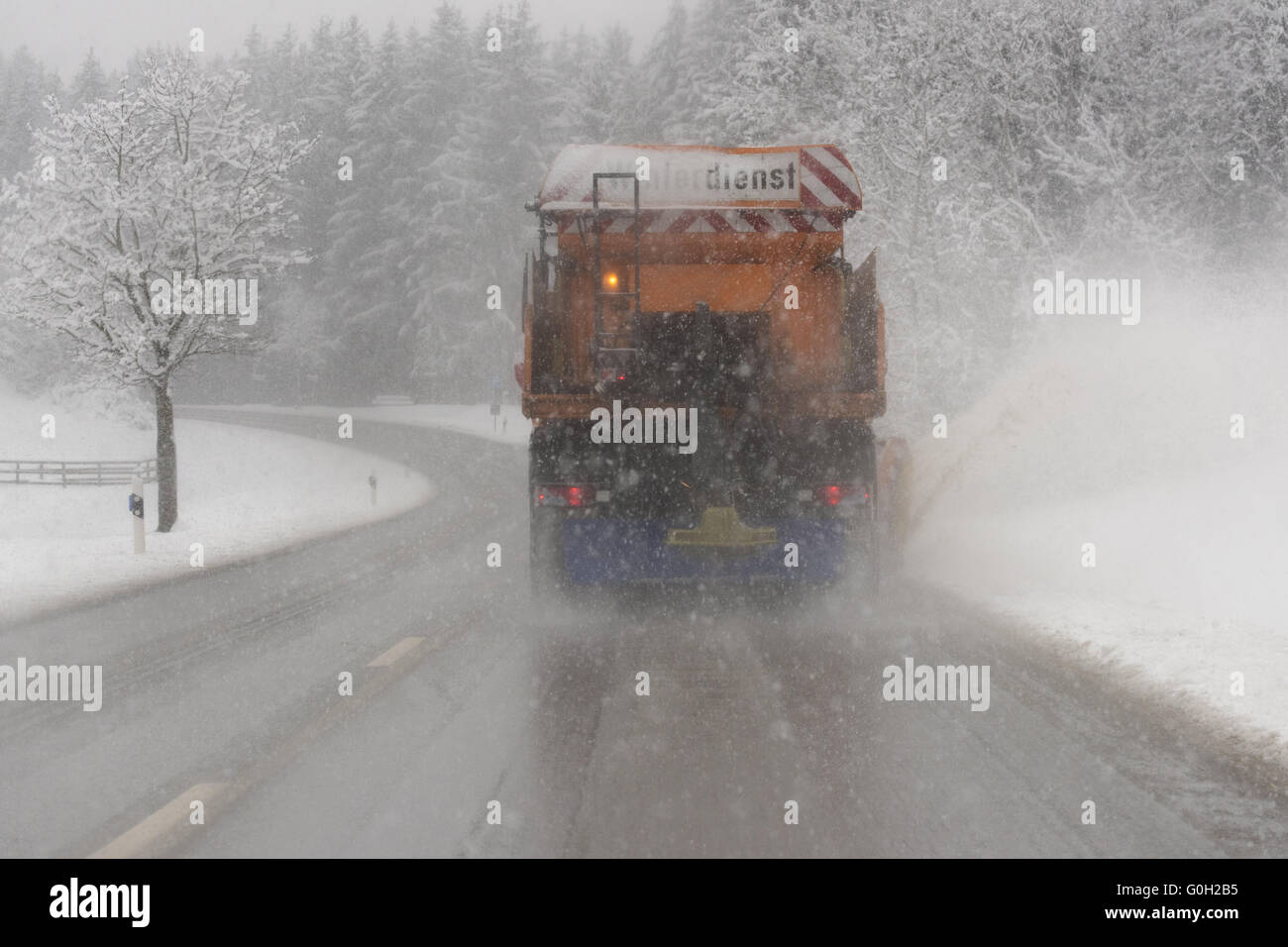 Winterdienst mit LKW auf der Straße mit Schnee Stockfoto