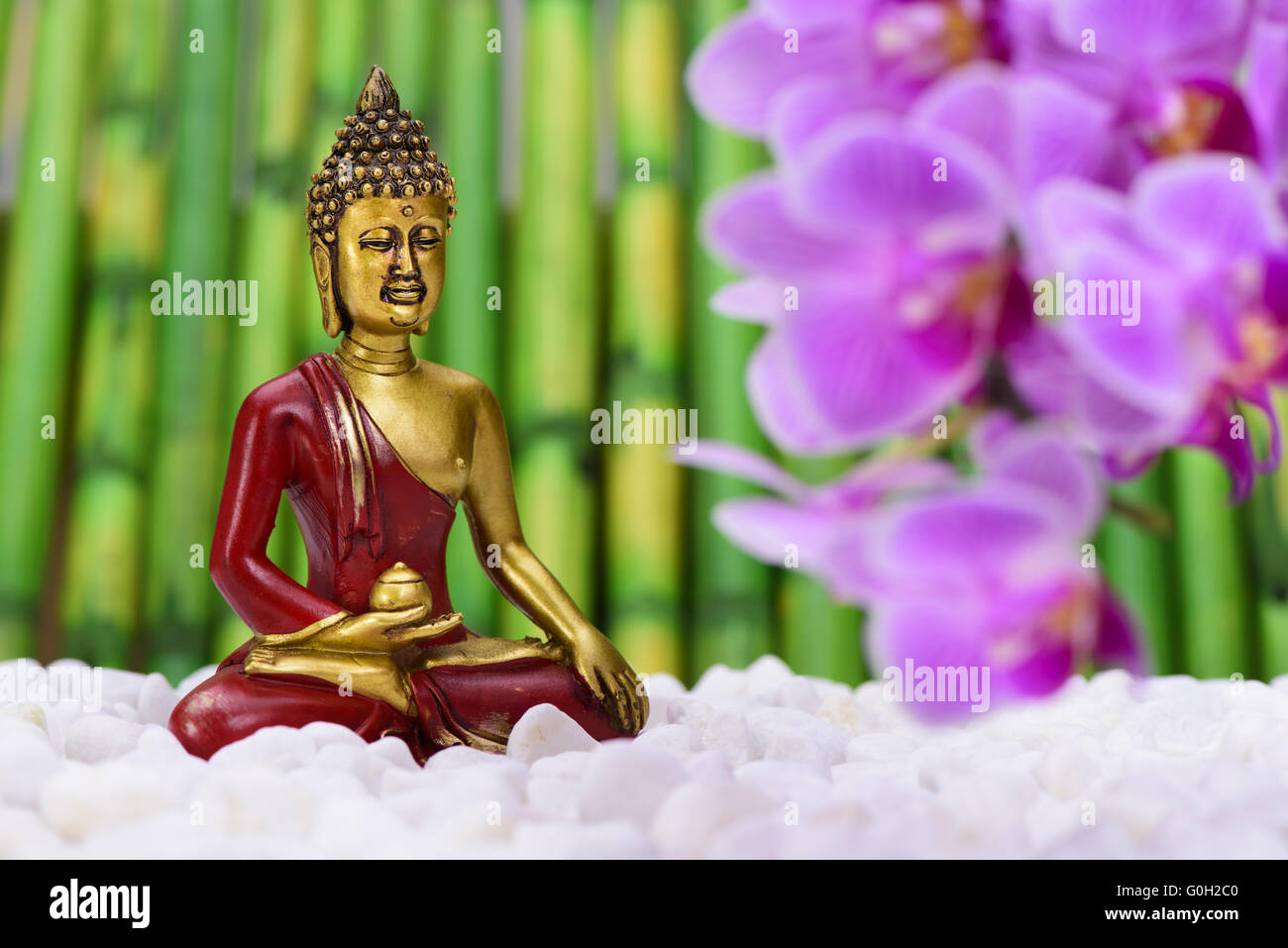 Buddhafigur sitzend im ZEN-Garten Stockfoto