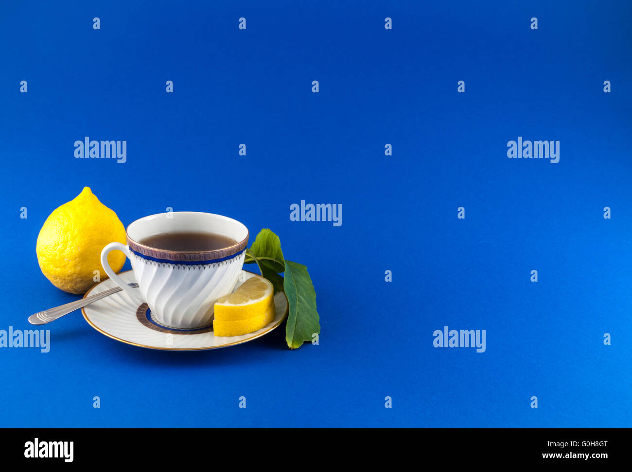 Teetasse auf farbigem Hintergrund mit Zitrone Obst und Zitrone Blatt Stockfoto