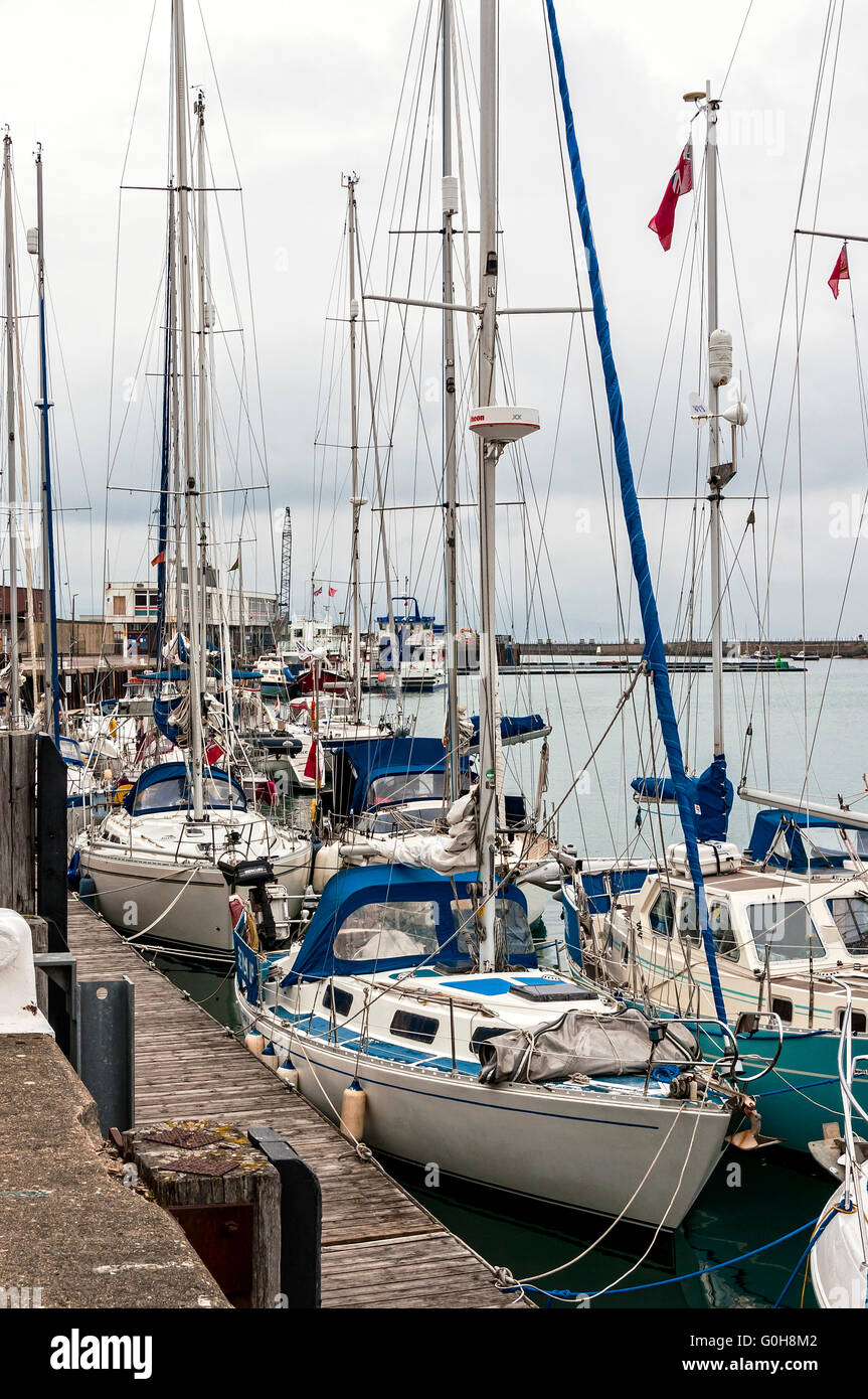 Weiße Yachten und andere Sportboote sind ihre Liegeplätze vertäut an einem dumpfen bewölkten Tag in klein, aber voll Hafen von Weymouth Stockfoto