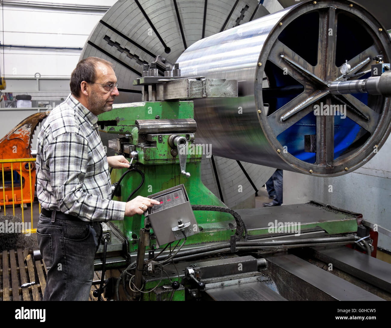 Ältere Arbeitnehmer in der Metallindustrie in CNC-Fräsmaschine. Stockfoto