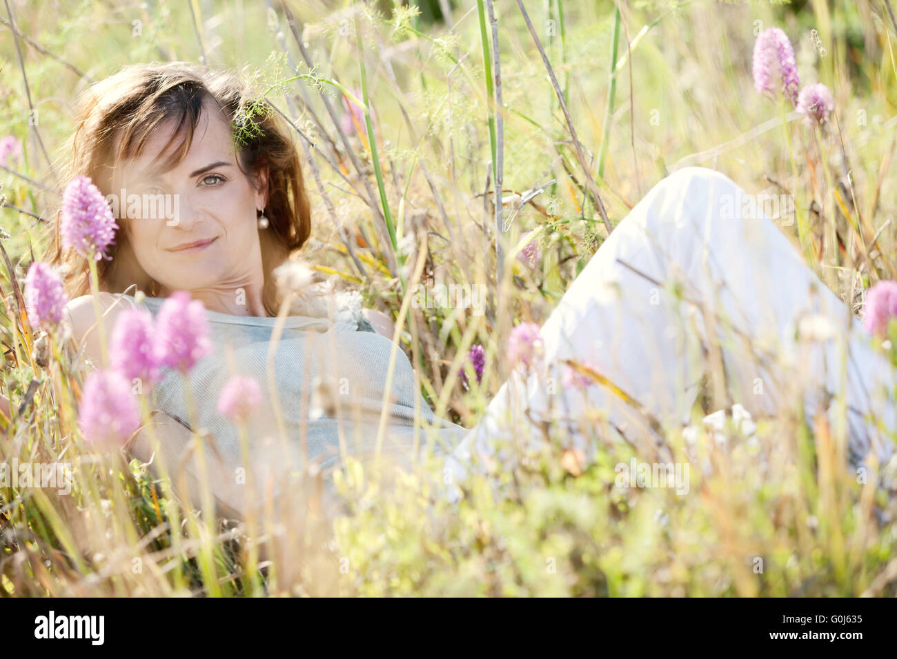 Brünette Frau lächelnd im Sommer im freien Stockfoto