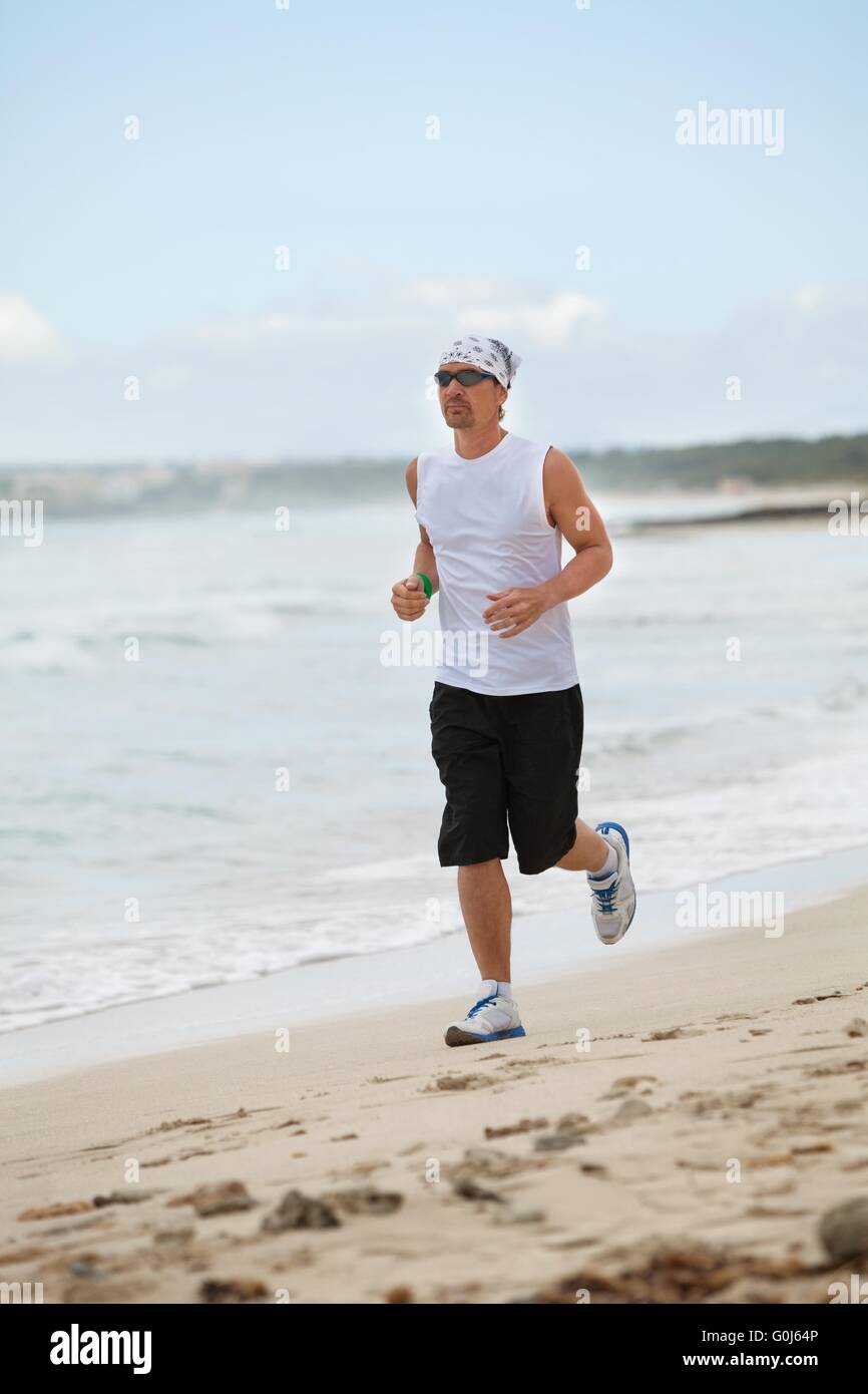 Man ist am Strand im Sommer Sport Fitness Joggen. Stockfoto