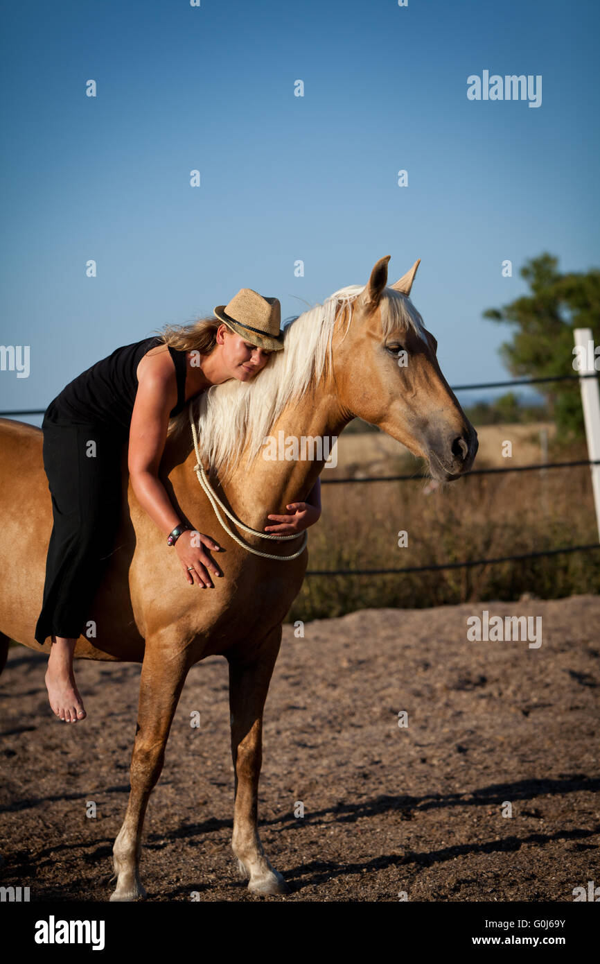 junge Frau Training Pferd draußen im Sommer Stockfoto