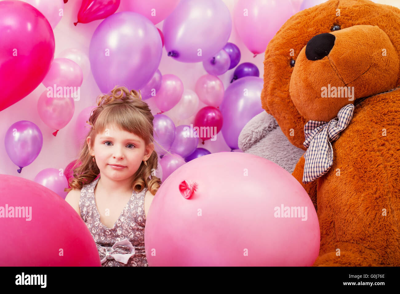 Schönen lockigen Mädchen posiert unter rosa Ballons Stockfoto