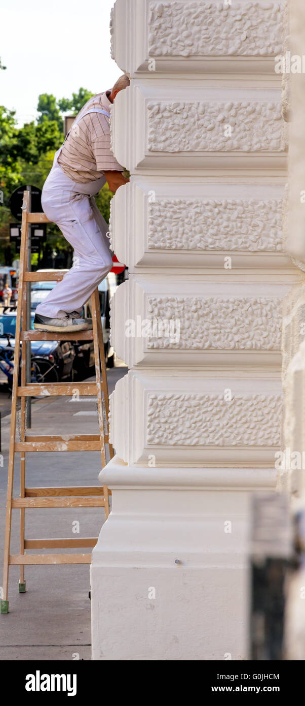 Maler auf einer Leiter am Arbeitsplatz Stockfoto